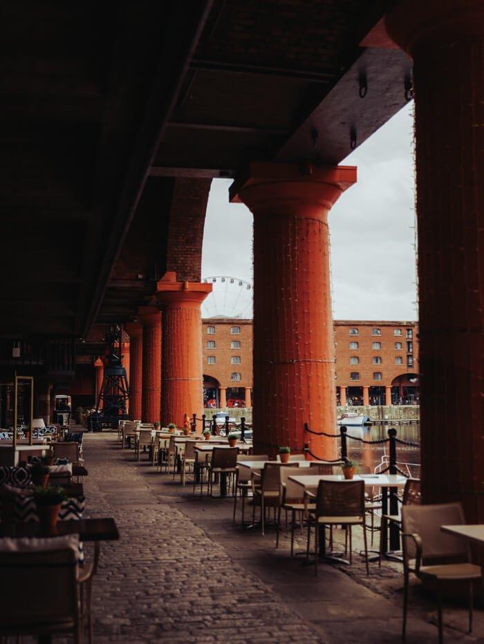 image of restaurant tables and pillars around a central lake